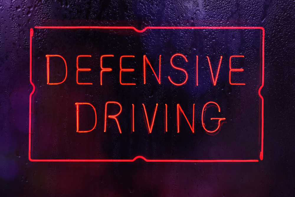 Neon,Defensive,Driving,Sign,In,Wet,Window