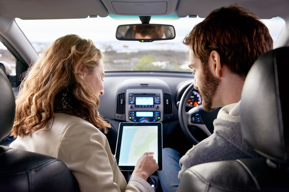 Couple,Using,Gps,On,Tablet,Compter,To,Navigate,In,Car