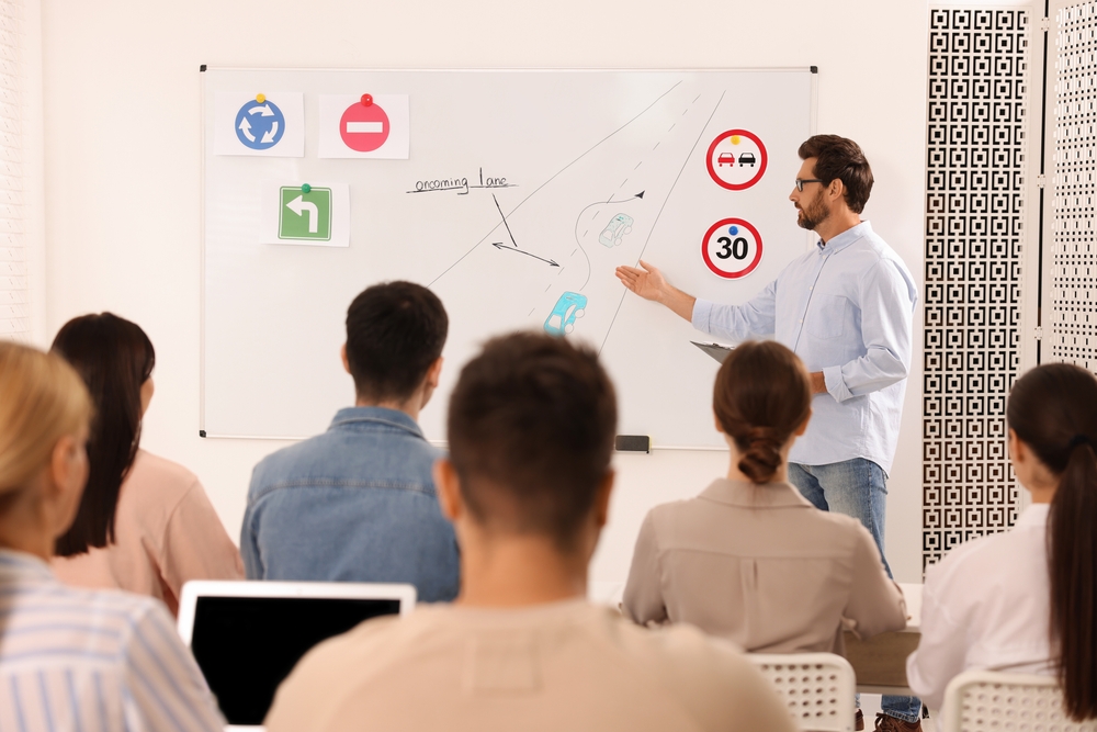 Teacher,Explaining,Traffic,Rules,To,Audience,During,Lesson,In,Driving