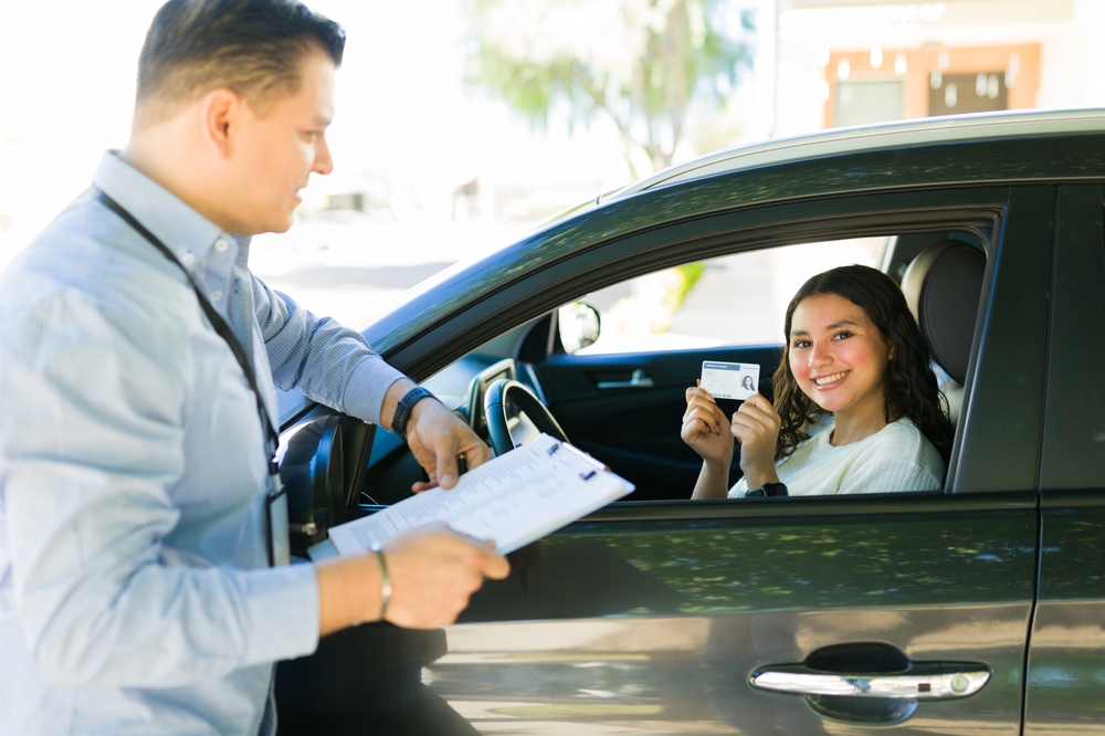 Portrait,Of,A,Cheerful,Teen,Girl,Showing,Her,Driver's,License
